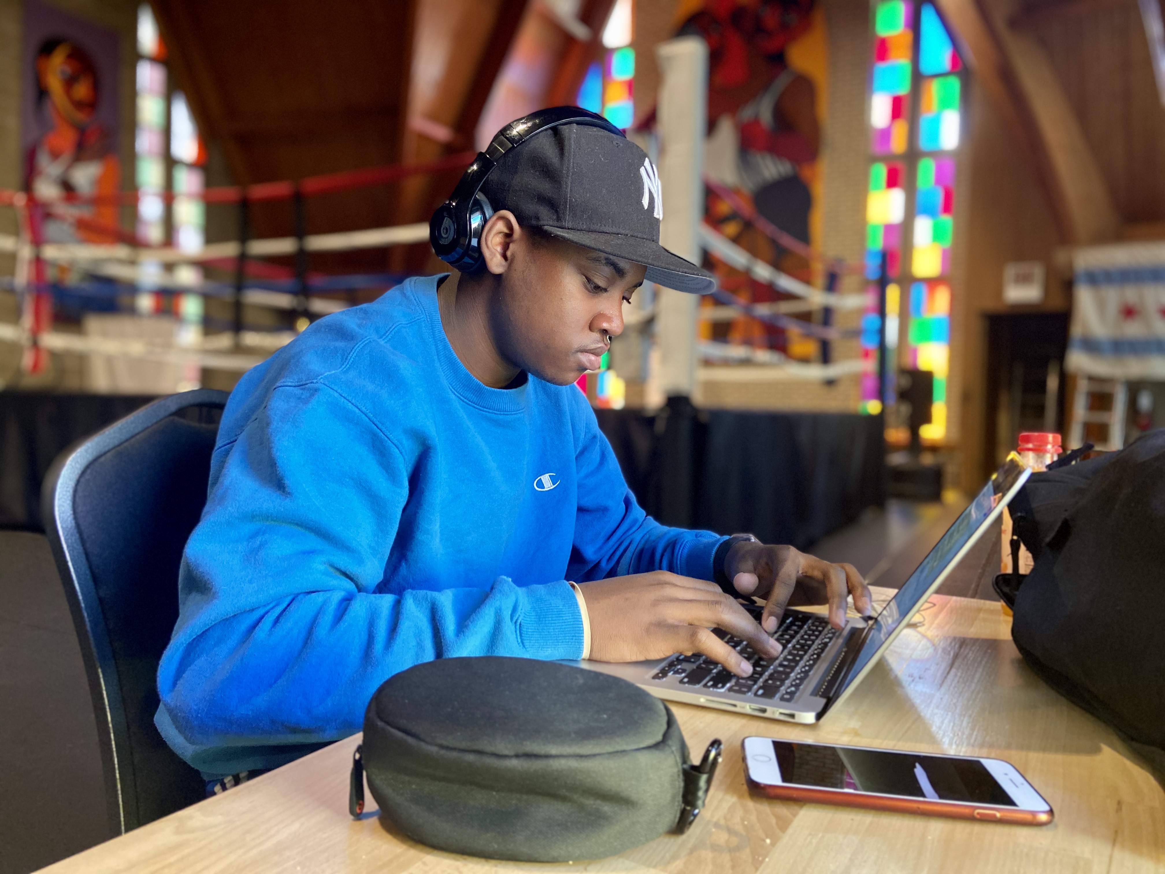 A Bloc student studies on a laptop in the gym